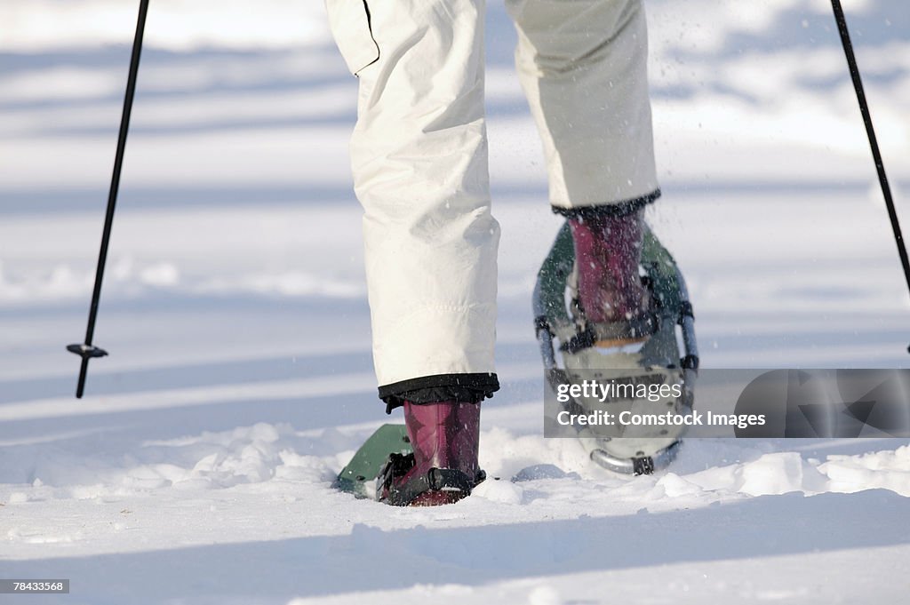 Legs of person snowshoeing