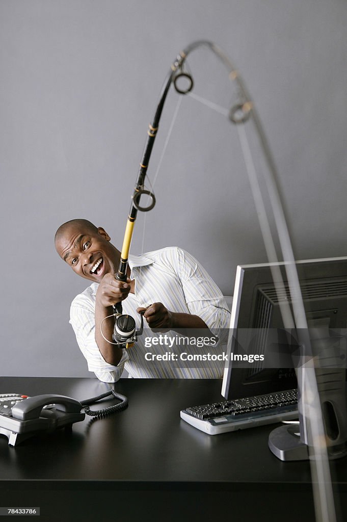 Businessman fishing from desk