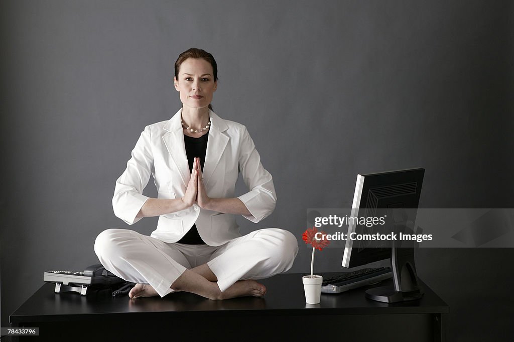 Businesswoman meditating on desk