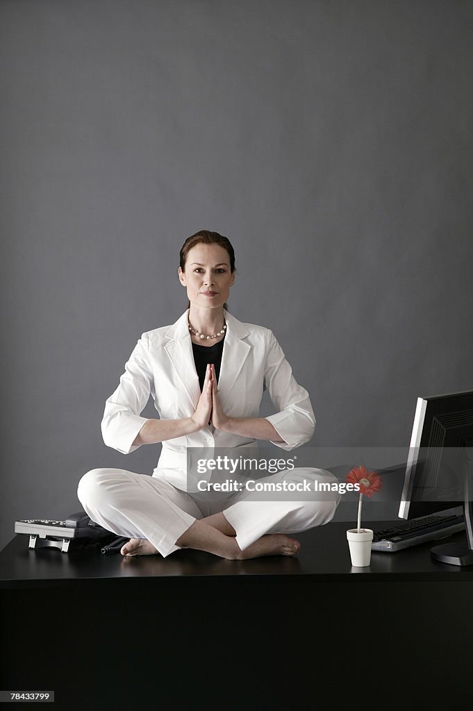 Businesswoman meditating on desk