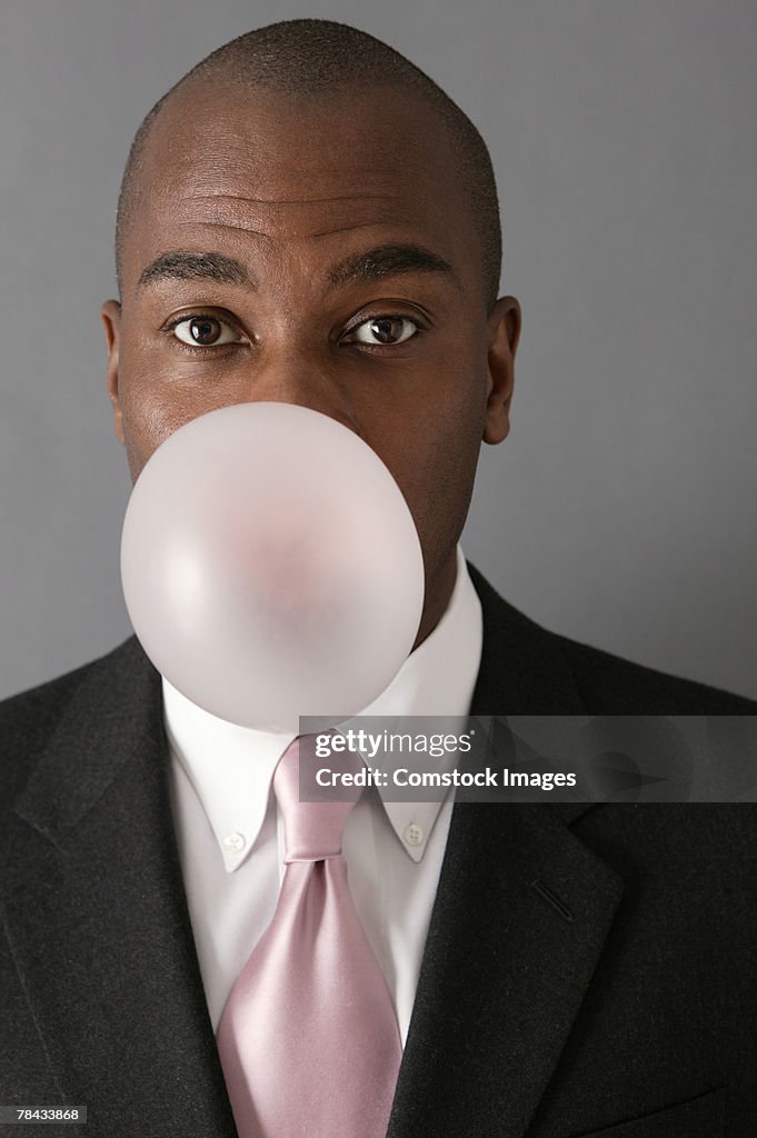 Businessman blowing bubble gum