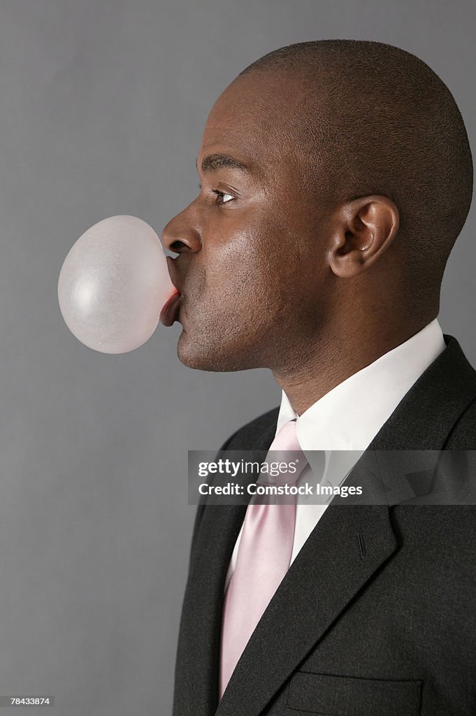 Businessman blowing bubble gum