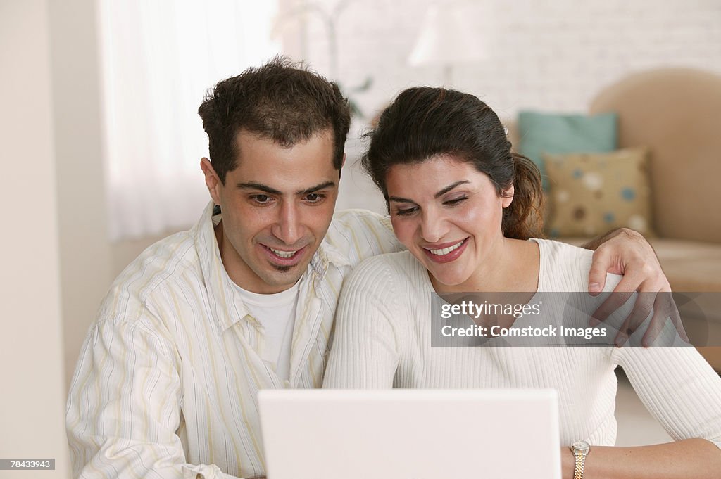 Couple using laptop at home