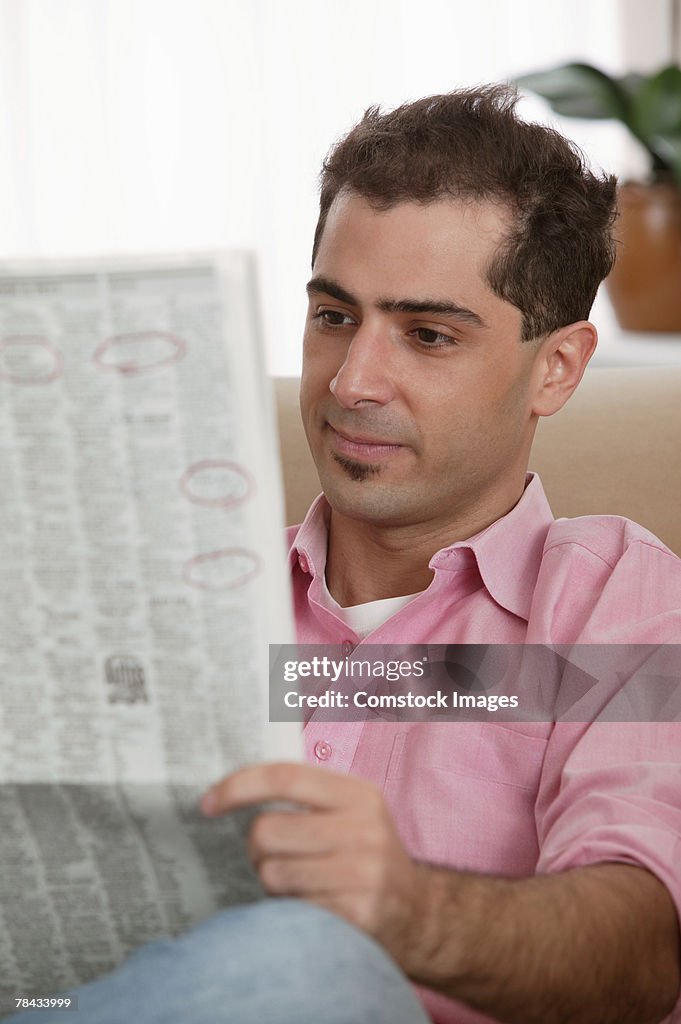 Man reading newspaper at home