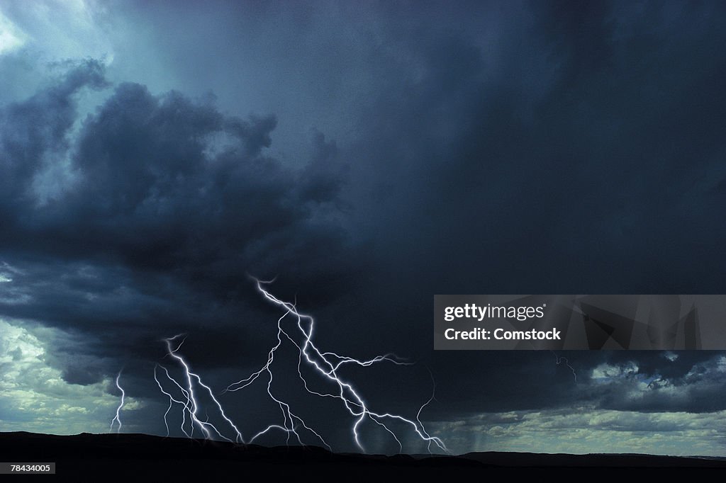 Multiple lightning bolts over rural landscape