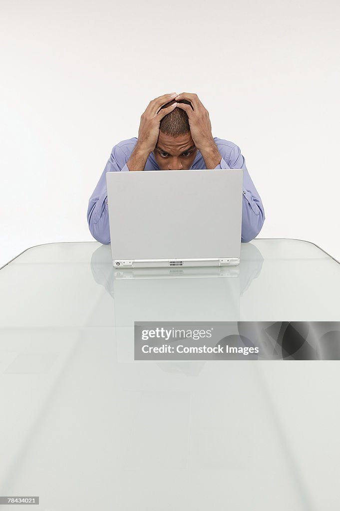 Frustrated businessman using a laptop