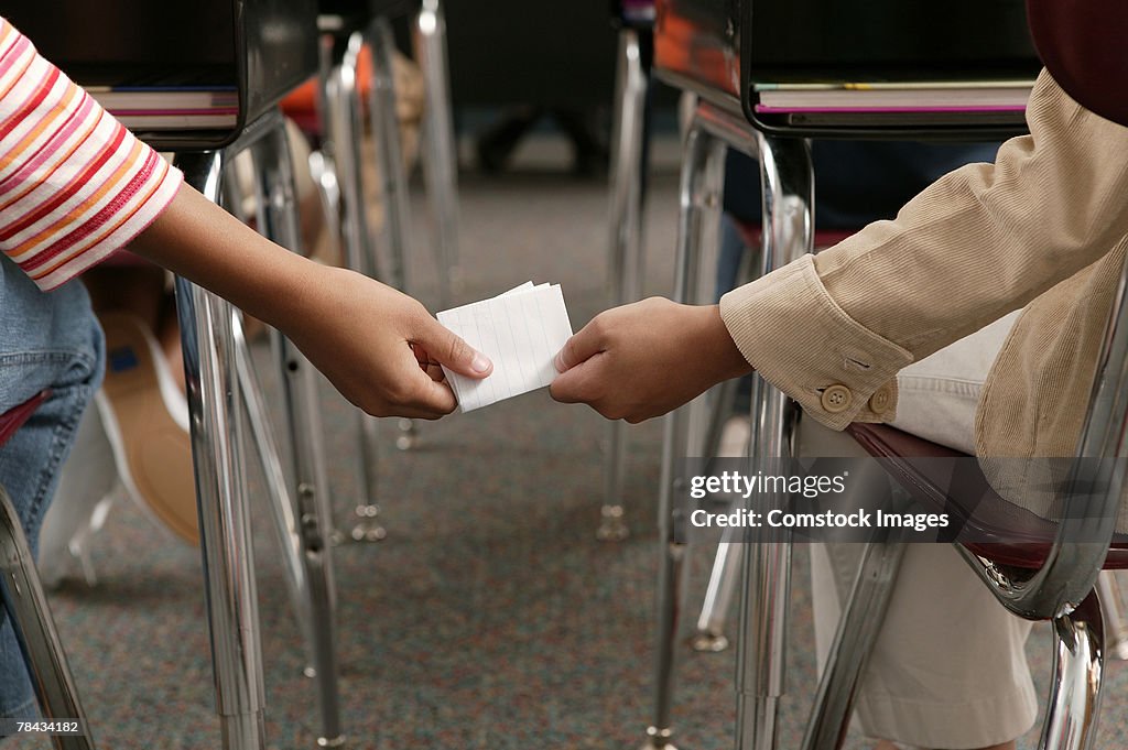 Students passing note in class