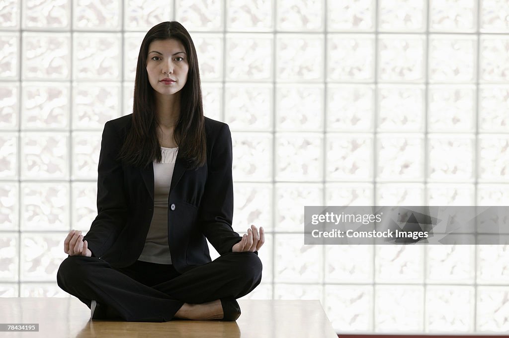 Businesswoman sitting in meditation pose