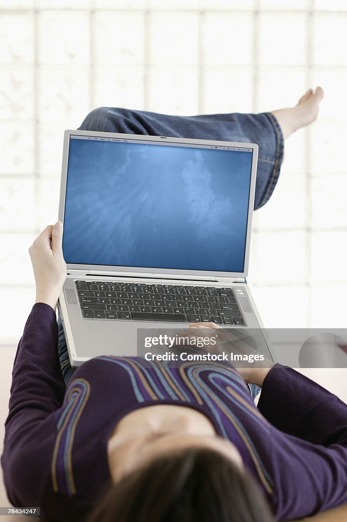 Woman lying down and using laptop