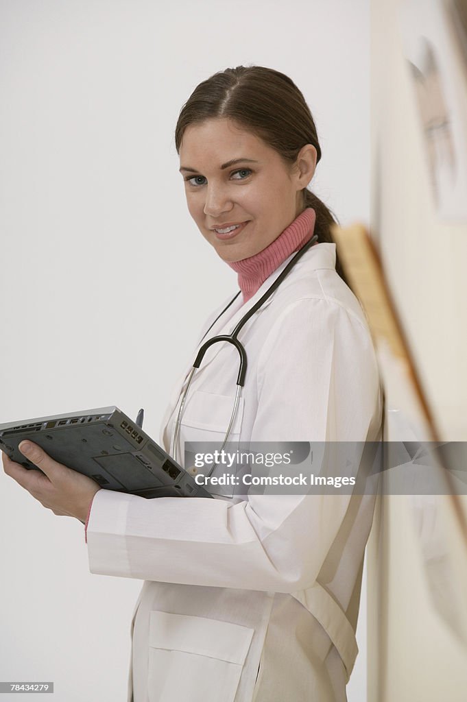 Doctor standing in hallway with laptop computer