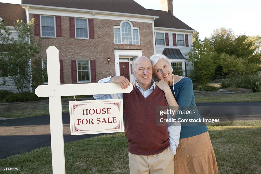 Couple by real estate sign