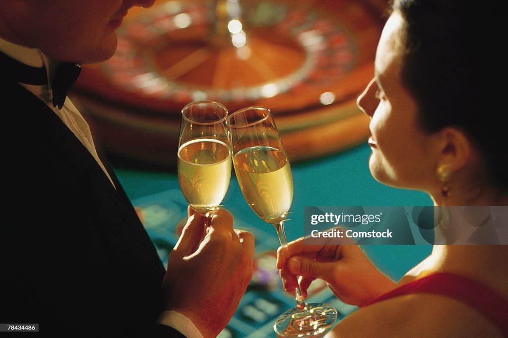 Couple in casino toasting champagne