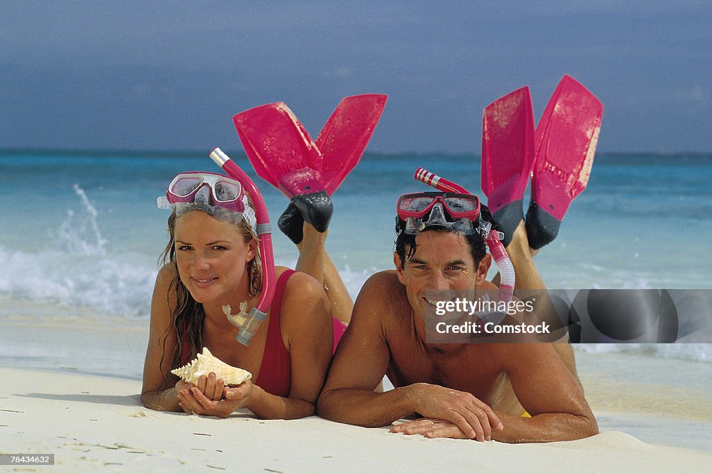 Couple in snorkel gear on the beach