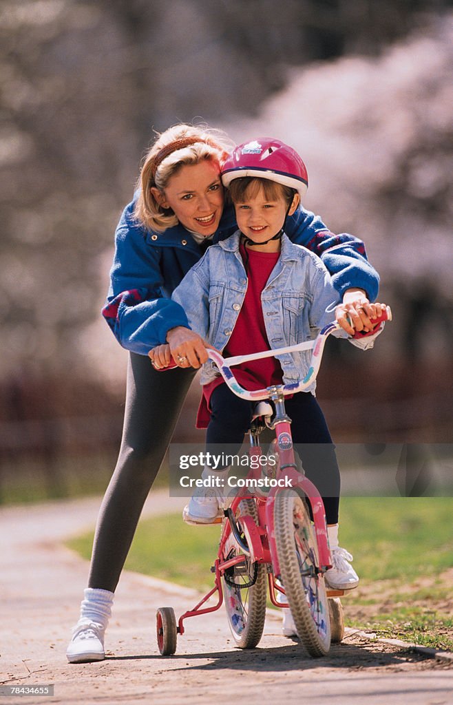 Woman teaching daughter to ride a bicycle