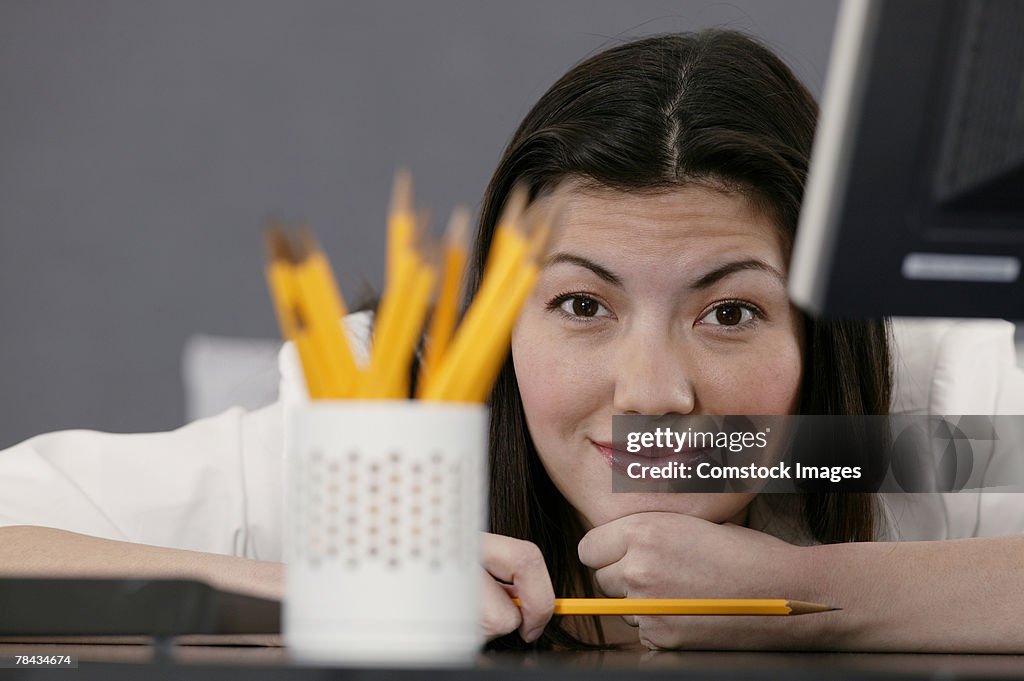 Businesswoman at desk with pencils