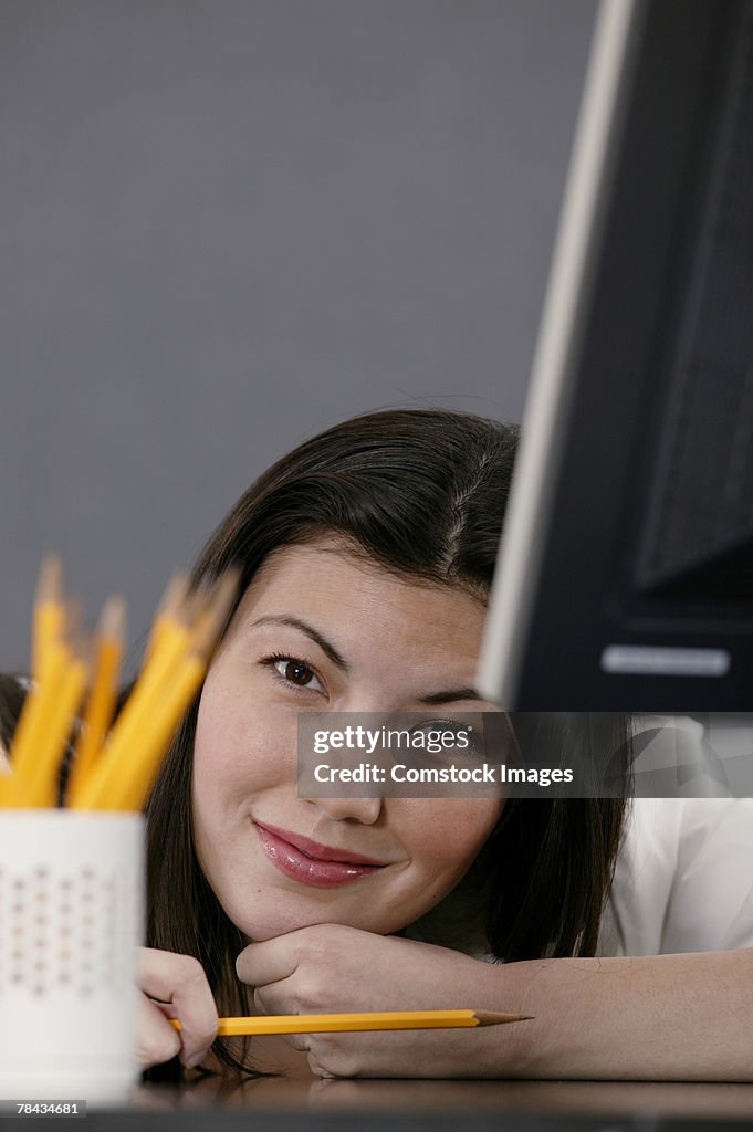 Businesswoman resting on chin at desk