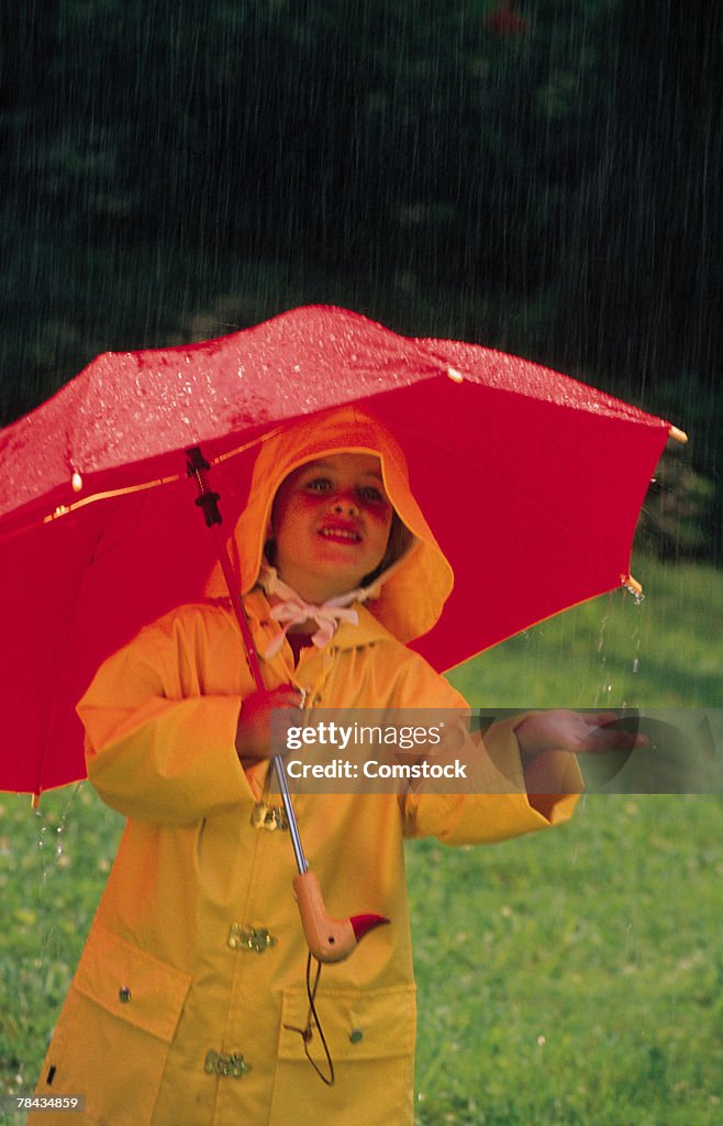 Child wearing a raincoat in the rain