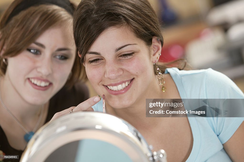 Teenage girls trying on makeup
