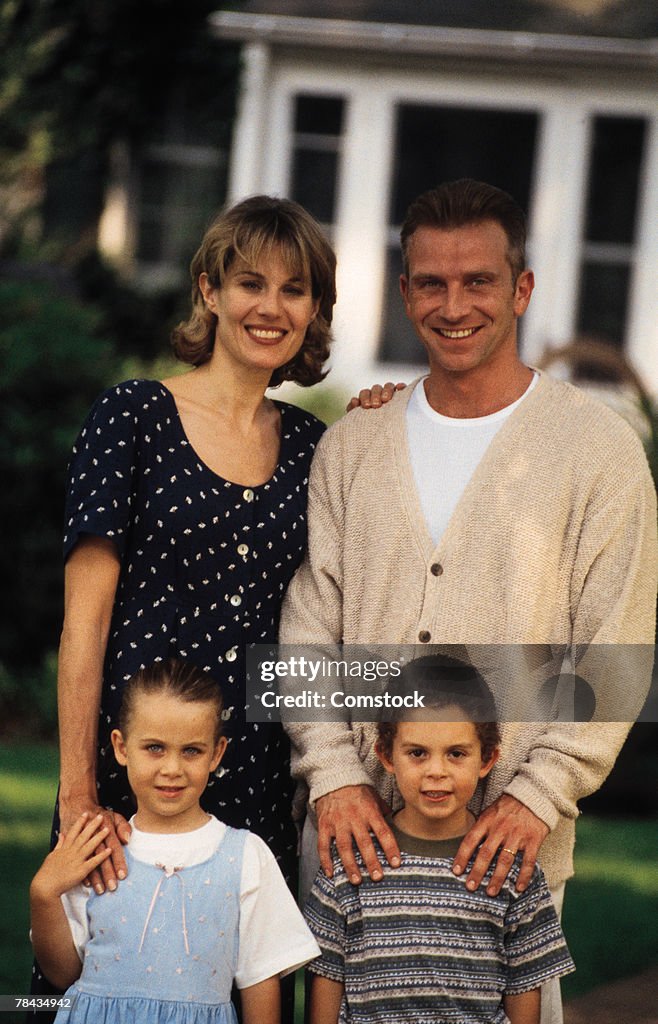 Family standing in front of house