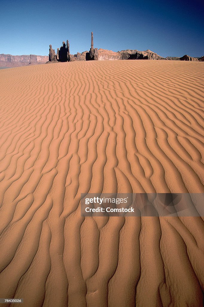 Sand dunes with rock formation in background