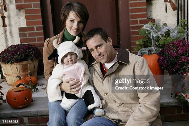 parents with baby in cow costume - baby cow costume stock pictures, royalty-free photos & images