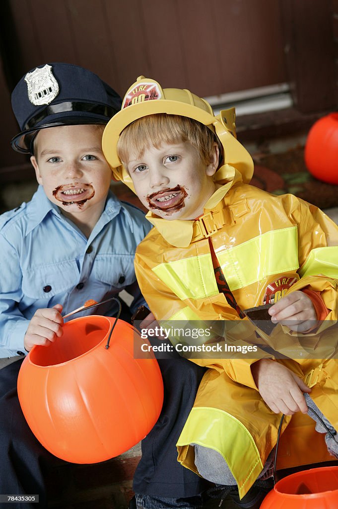 Boys in Halloween costumes with chocolate on faces