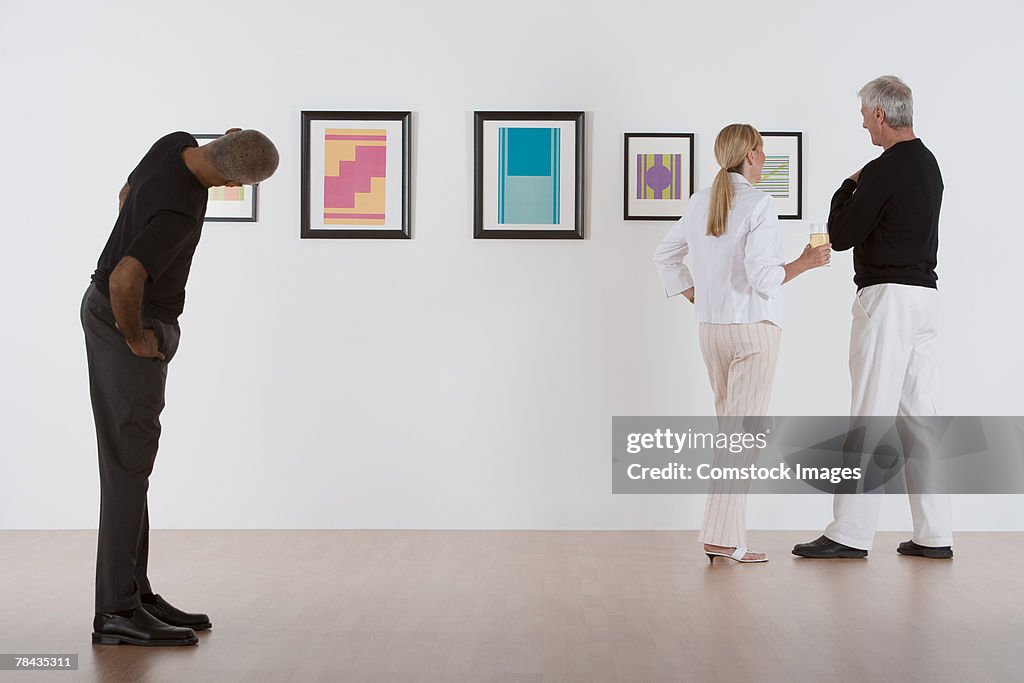 People admiring artwork in gallery