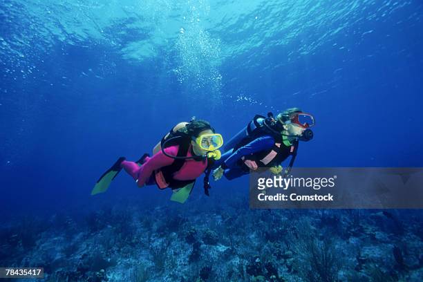 scuba divers over shallow reefs , caribbean - buceo con equipo fotografías e imágenes de stock