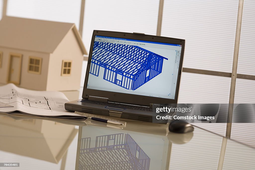 Laptop, model house, and blueprints