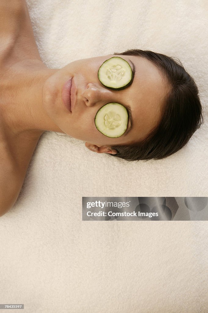 Woman at spa with cucumber slices covering eyes