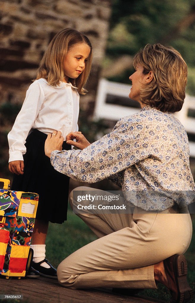 Mother helping daughter get ready for school