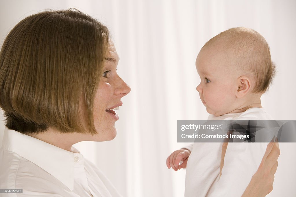 Mother holding her baby face to face