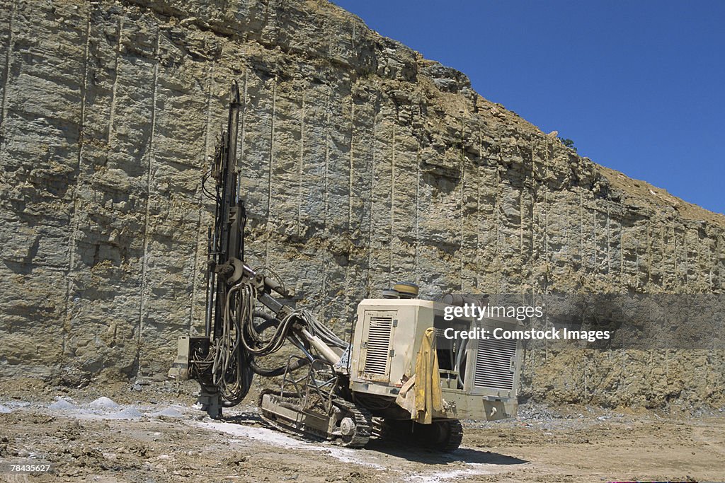 Blast hole drill  digging through rock wall