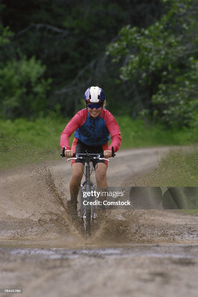 Woman mountain biking through the mud in British Columbia , Canada