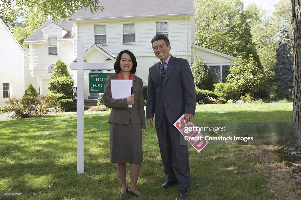 Realty agents with sold sign