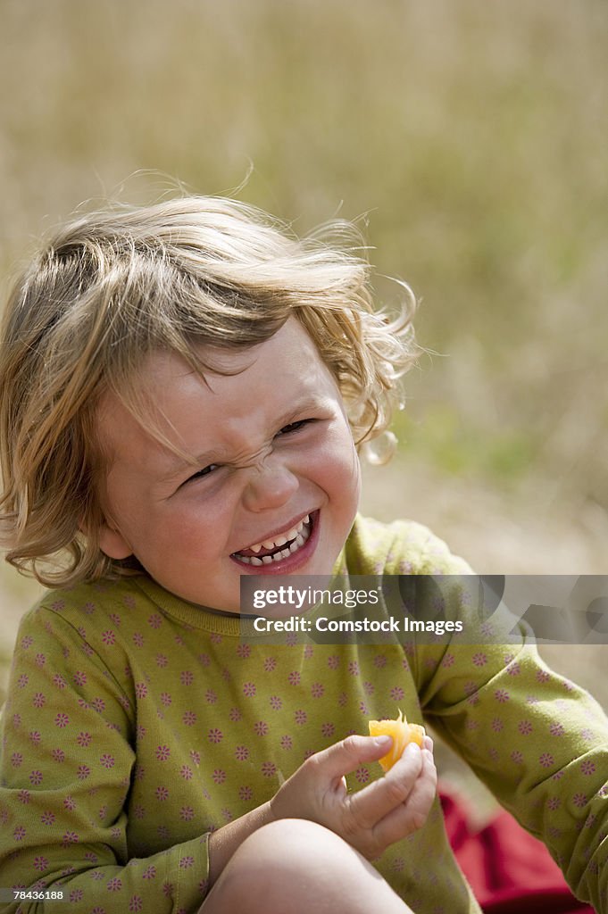 Girl eating fruit and laughing