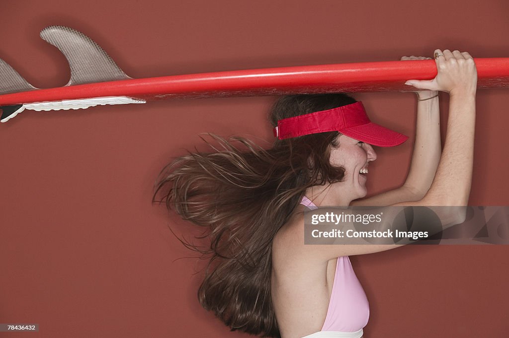 Woman carrying surfboard