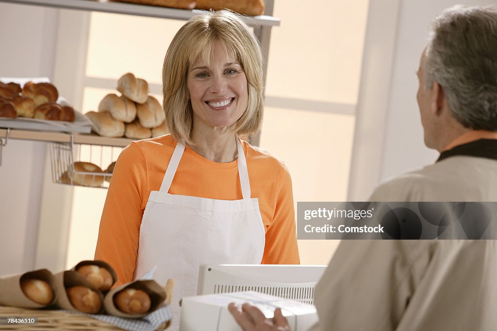 Woman helping customer in bakery