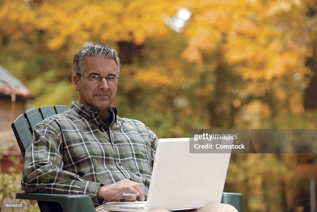 Man sitting outside using laptop computer