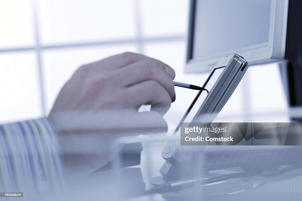 Hand using PDA on desk