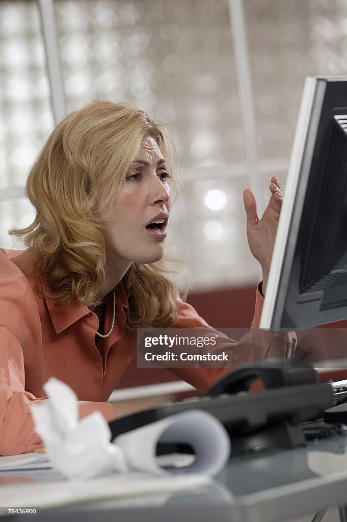 Stressed woman using desktop computer