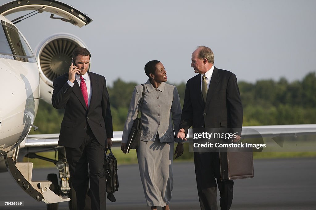 Men and woman talking near airplane