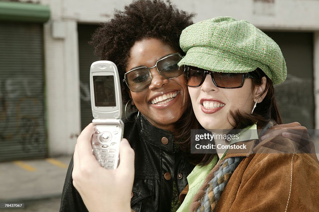 Two women taking a picture with camera phone