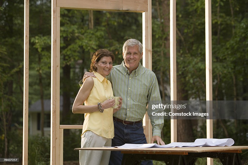 Couple reviewing blueprints at construction site
