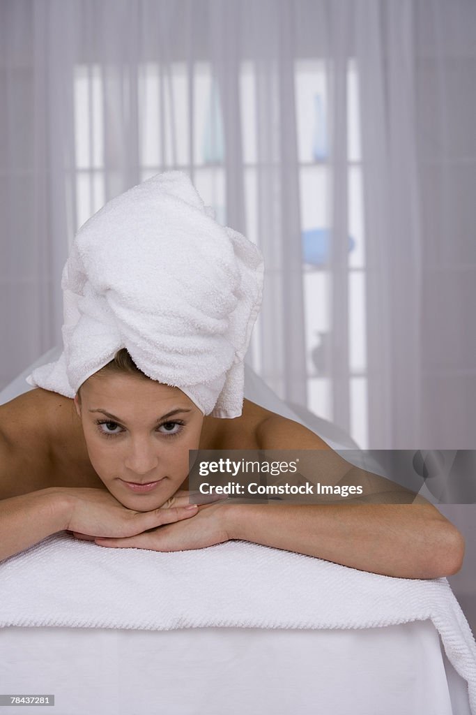 Woman lying down with towel on her head