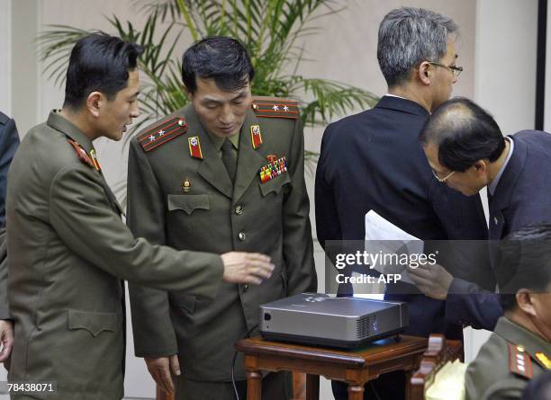 Supporting officers of the South Korean delegation block a projector showing a North Korean slide presentation of a proposal map relating to joint...