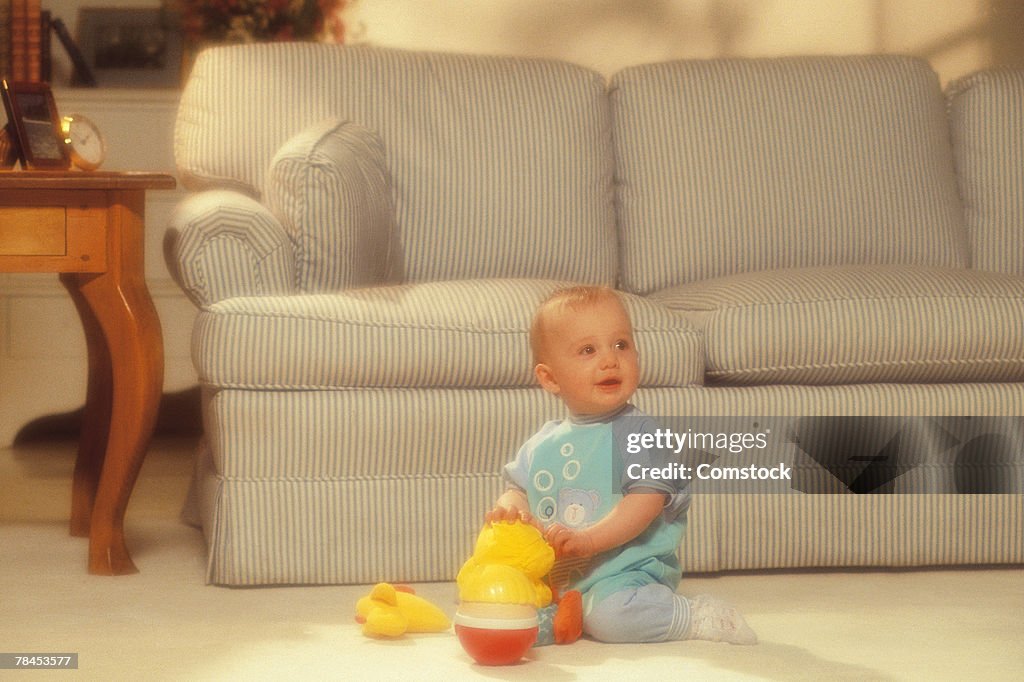 Baby playing with toys in living room