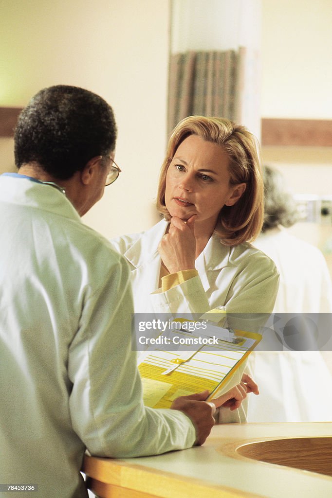 Two doctors talking at nurse's station