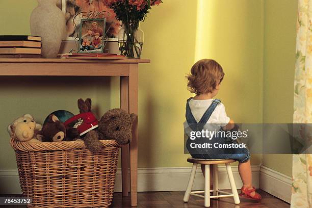 young child sitting in corner as punishment - time out stock-fotos und bilder