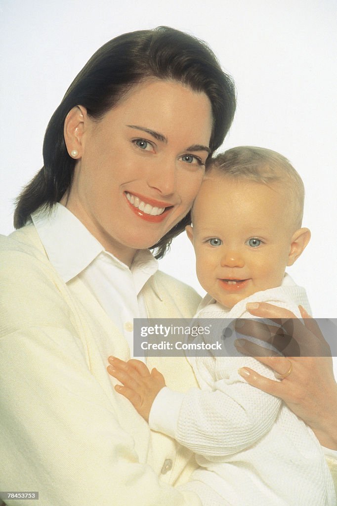 Mother holding child and posing for studio shot